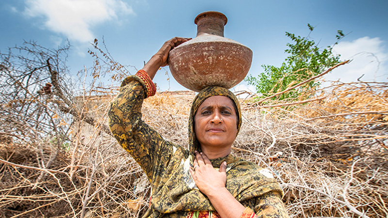 Femme pakistanaise portant une jarre sur la tête.